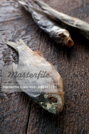 Salty dry river fish is  on a brown wooden background