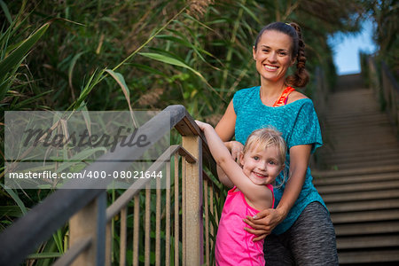 Portrait of healthy mother and baby girl outdoors in the evening