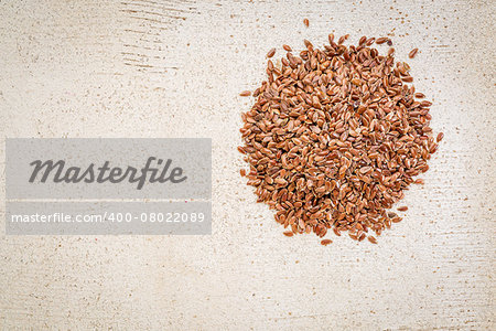 a small pile of brown flax seeds on a white painted, rustic barn wood with a copy space