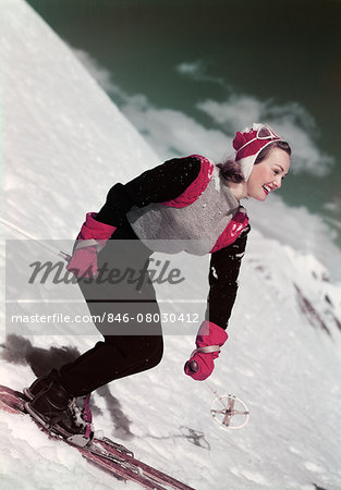 1940s SMILING WOMAN SKIING DOWNHILL
