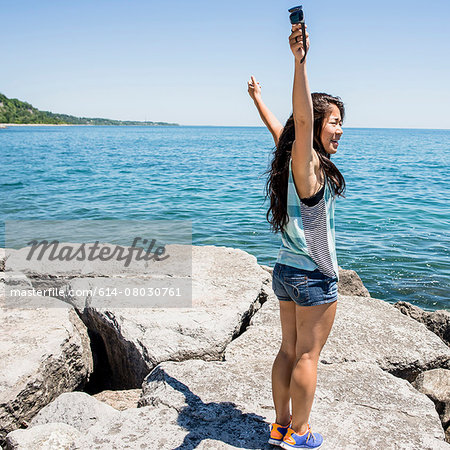 Young woman standing on rocks, Scarborough Bluffs, Toronto, Ontario, Canada