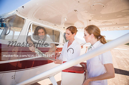 Medical staff carrying cooler box by plane, Wellington, Western Cape, South Africa