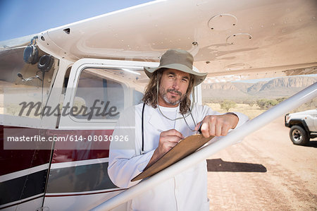 Medical staff writing on clipboard beside plane, Wellington, Western Cape, South Africa