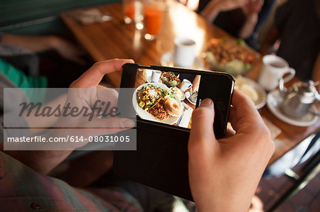 Cropped shot of man taking photograph of meal in vegetarian restaurant