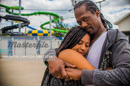 Father hugging daughter at amusement park