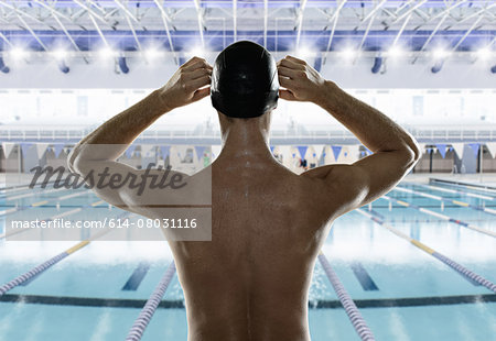 Male swimmer preparing himself at edge of swimming pool