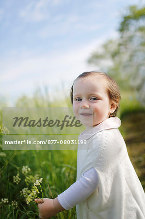 young girl carrying a flower in the country