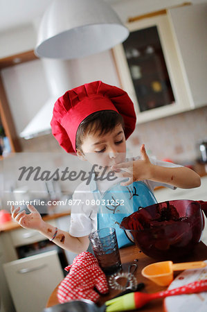 A little boy tasted the chocolate cake preparation