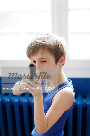 A boy playing with a gun toy