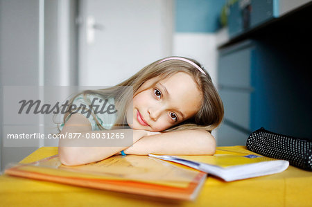 A 10 years old girl posing with her school books