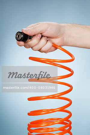 Man holding a pneumatic air hose connector in his hand.