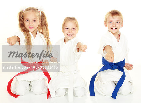 Cheerful young children to sit in a ceremonial kimono karate pose and hit a punch