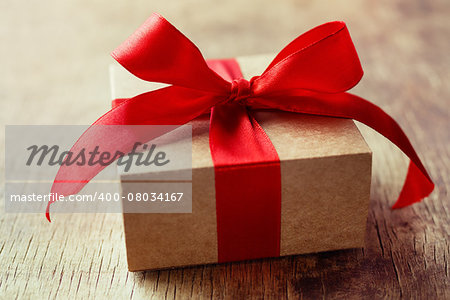 Gift with a red bow on a wooden background