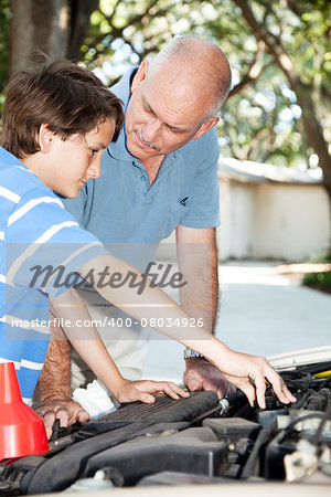 Father teaching his son how to do auto repairs, oil change, etc.
