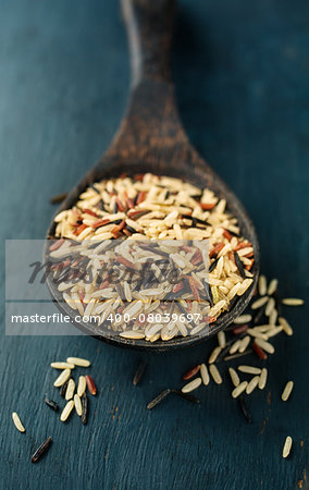 Various types of rice in a wooden spoon, close-up
