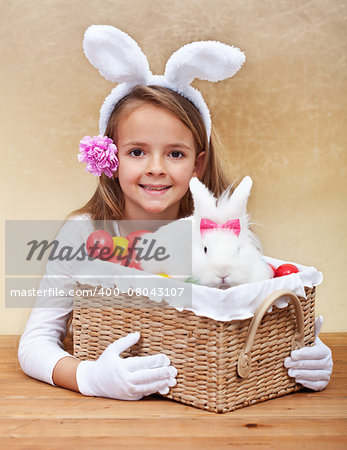 Happy spring girl with easter basket - holding colorful eggs and white rabbit