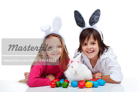 Happy kids with the easter bunny and colorful eggs - wearing bunny ears