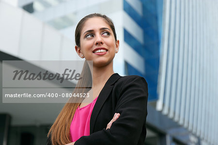 Portrait of young adult hispanic business person with arms crossed, looking at side and smiling