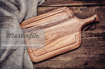 Empty vintage cutting board on old wooden background. Food background concept