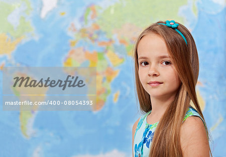 Young girl in front of world map - in geography class, with copy space