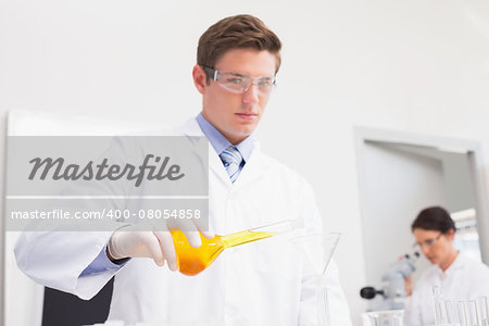 Scientists working attentively with test tube and microscope in laboratory