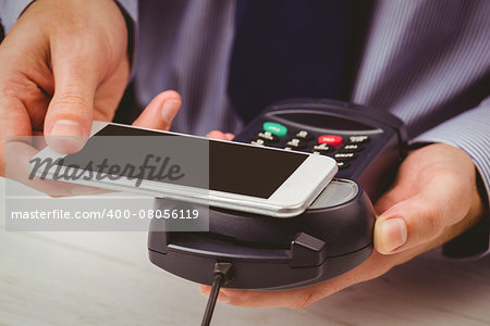 Man using smartphone to express pay on a wooden table