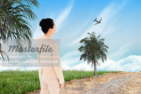 Unsmiling asian businesswoman against road leading out to the horizon