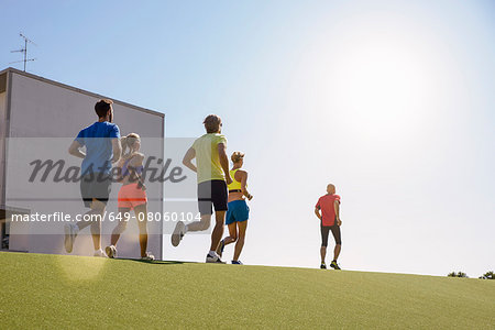 Small group of people running on grass
