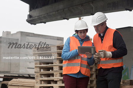 Dock worker using digital tablet at port