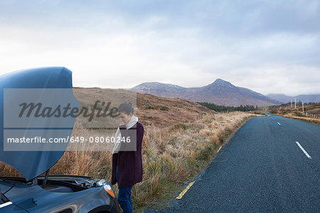 Woman by stalled vehicle at roadside, Connemara, Ireland