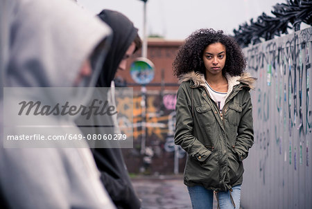 Teenagers standing against wall with graffiti