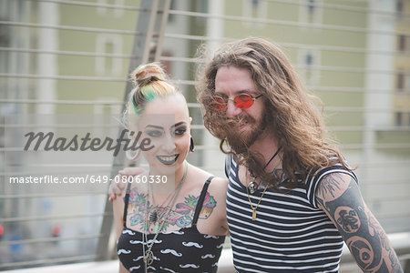 Punk hippy couple strolling and chatting on city street