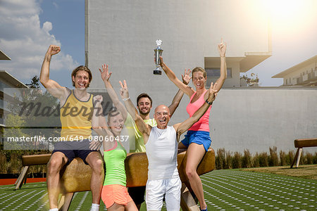 Portrait of gymnast team celebrating winners trophy