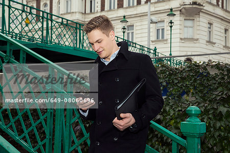 Businessman using smartphone by staircase