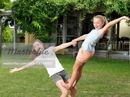 Two sisters doing acrobatics in garden