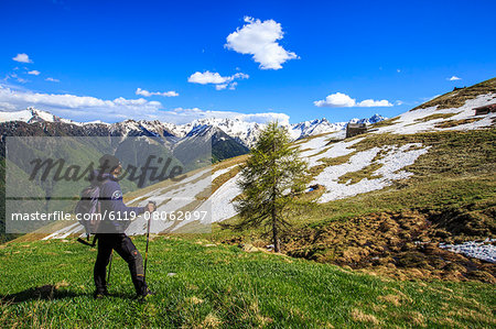 Hiker contemplating the landscape that can be seen from the Cima della Rosetta in the Orobie Alps in the spring, Lombardy, Italy, Europe