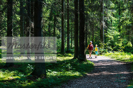 Mother with son walking through forest