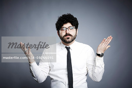Portrait of young man, hands open in questioning expression