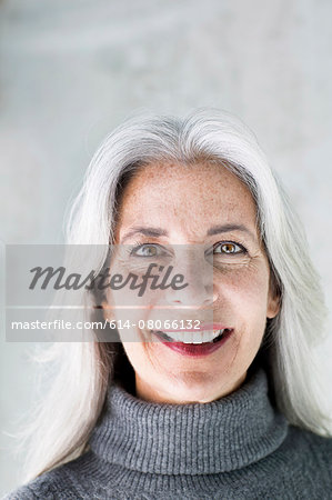 Portrait of beautiful smiling mature woman with long grey hair