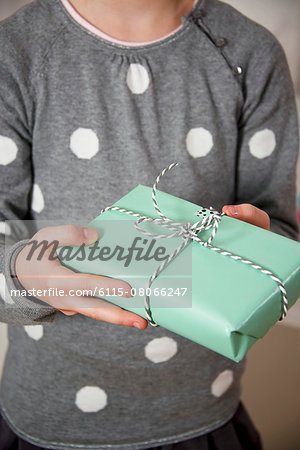 Girl on birthday party holding a gift box, Munich, Bavaria, Germany