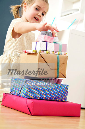 Girl on birthday looking at stack of presents, Munich, Bavaria, Germany