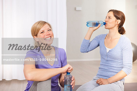 Women drinking from water bottles on Pilates class