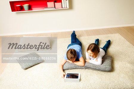 Children using tablet computer at home, Munich, Bavaria, Germany