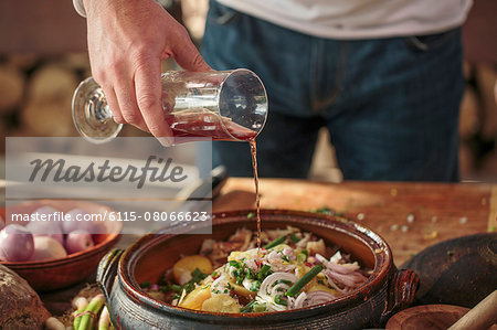 Person preparing potato salad adding sauce Person preparing potato salad adding sauce