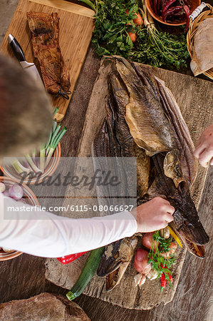 Person preparing pike on cutting board