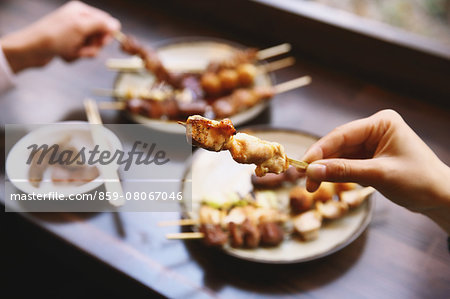 People eating Japanese style Yakitori