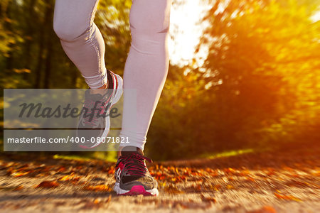 Fitness Girl running at sunset in forest
