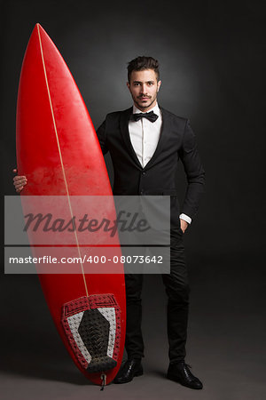 Handsome latino young man holding a surf board