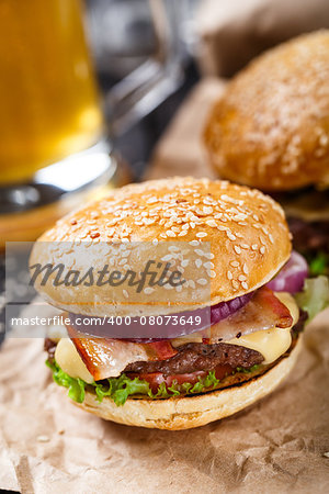 Delicious burger with beef, bacon, cheese and vegetables