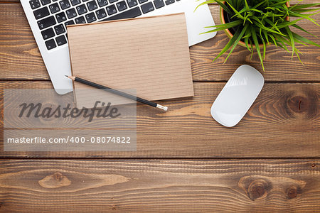 Office desk table with computer, supplies and flower. Top view with copy space